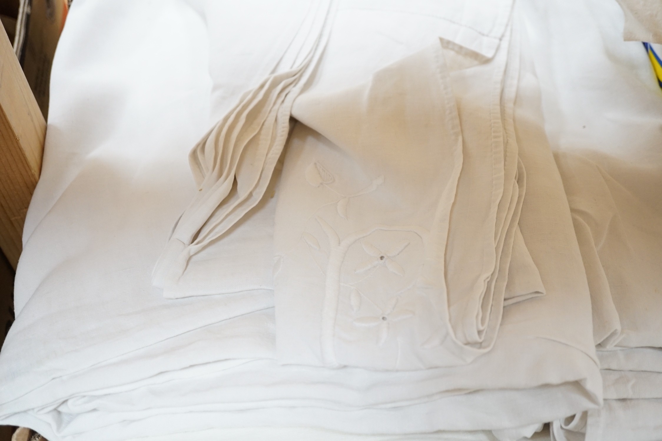 A quantity of French provincial linen sheets, some with monograms and button holed turn back